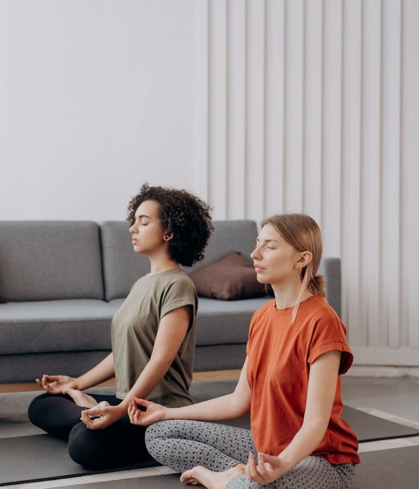 Woman performing a yoga pose in a bright, minimalist room.